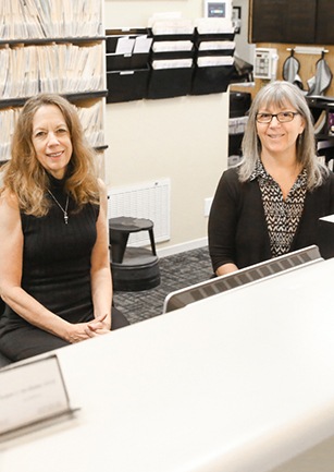 Two women smiling at front desk
