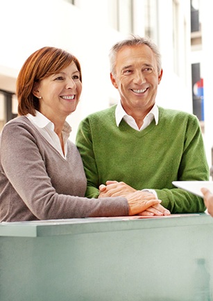 Older man and woman at reception desk