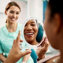 Patient smiling at reflection in treatment chair
