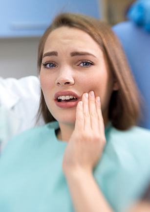 Woman holding cheek in pain