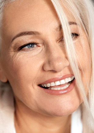 closeup of woman smiling after getting dental implants in Cambria