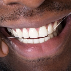 closeup of man flossing his teeth