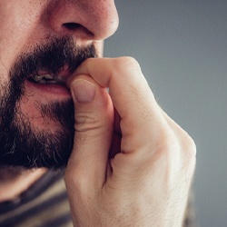 closeup of man biting fingernails