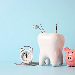 a piggy bank next to a tooth and dental tools