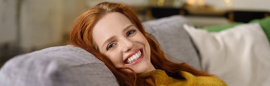 woman on a couch smiling