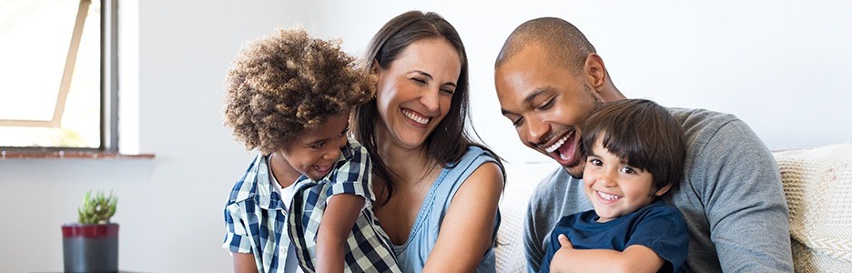 Laughing family of four on couch