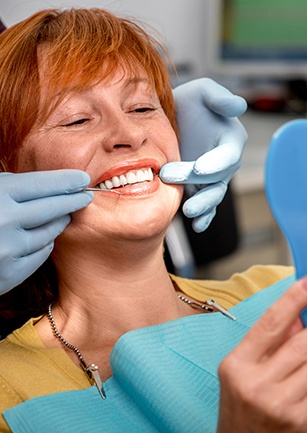 Woman looking at smile in mirror