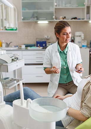 Dentist talking to patient in treatment room