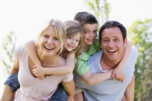 A family smiling outside.