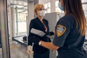 female airport security using scanner on businesswoman 