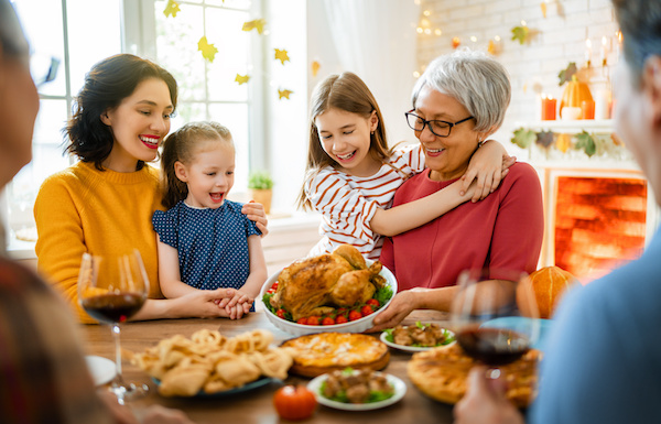 family gathered around holiday table looking at turkey