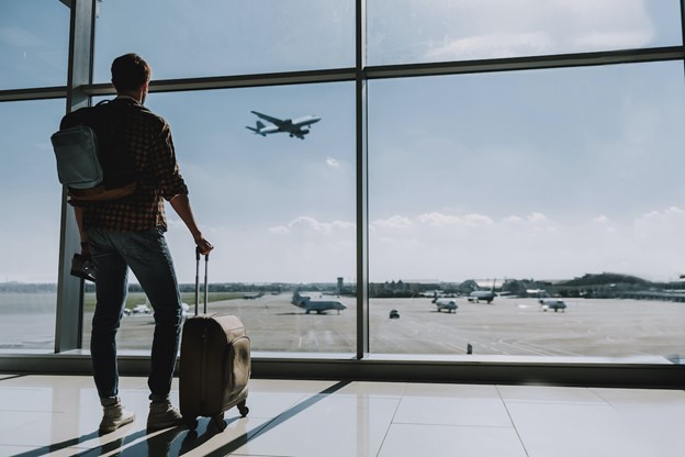 patient standing at an airport staring out window