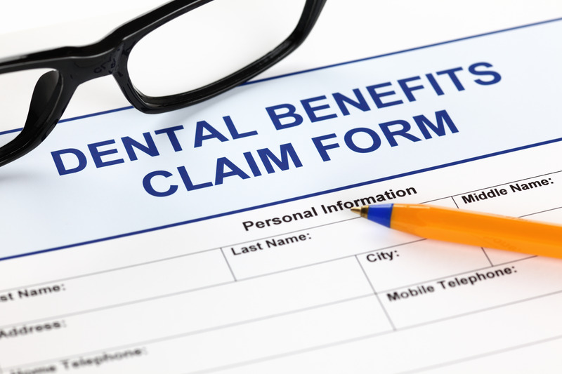 Patient using a dental insurance form to plan for dental implants